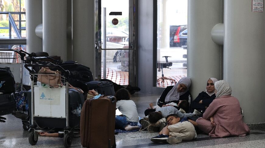 Passengers wait for their flights at Beirut International Airport, where several major airlines have announced flight cancellations due to escalated hostilities between Hezbollah and Israel