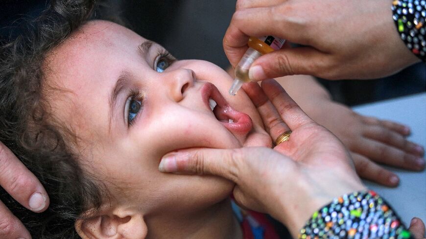 A child receives drops for the polio vaccine in Khan Yunis on September 5, 2024