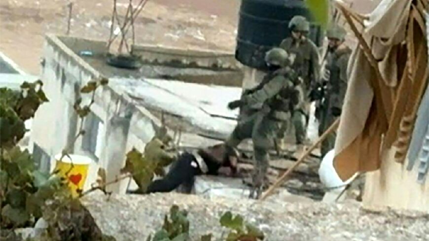 An image grab taken from an AFPTV video shows an Israeli soldier pushing an apparently dead  Palestinian off a rooftop during a raid in the occupied West Bank