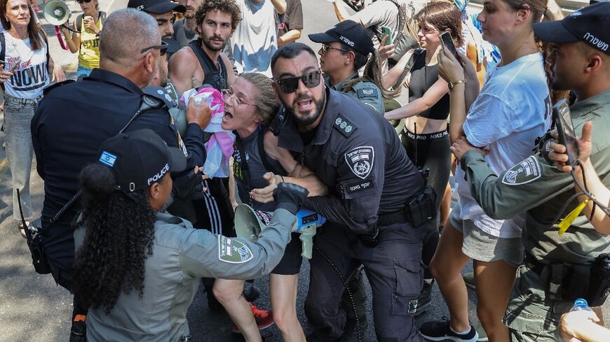 Policemen scuffle with a protester as families and supporters of Israeli hostages held in Gaza hold a rally calling for their release in Tel Aviv