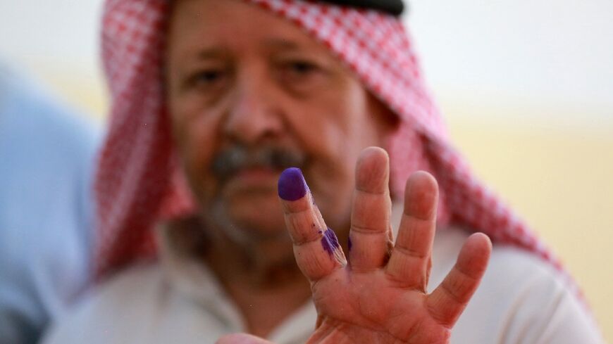 A man displays his ink-stained finger after voting