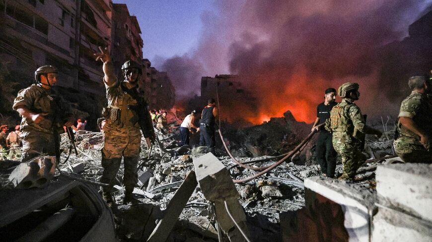 Lebanese soldiers gather over the rubble of a levelled buildings, following Israeli air strikes in the Haret Hreik neighbourhood of Beirut's southern suburbs