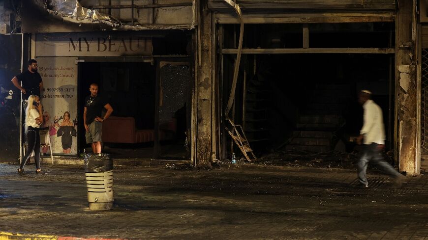 Residents inspect the damage in the Israeli city of Ramla from a deadly car explosion that police say was likely a gangland hit.