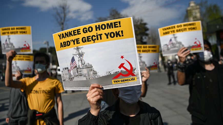 A group of protesters hold placards reading "Yankee go Home - No way to USA," in Istanbul, on April 14, 2021.