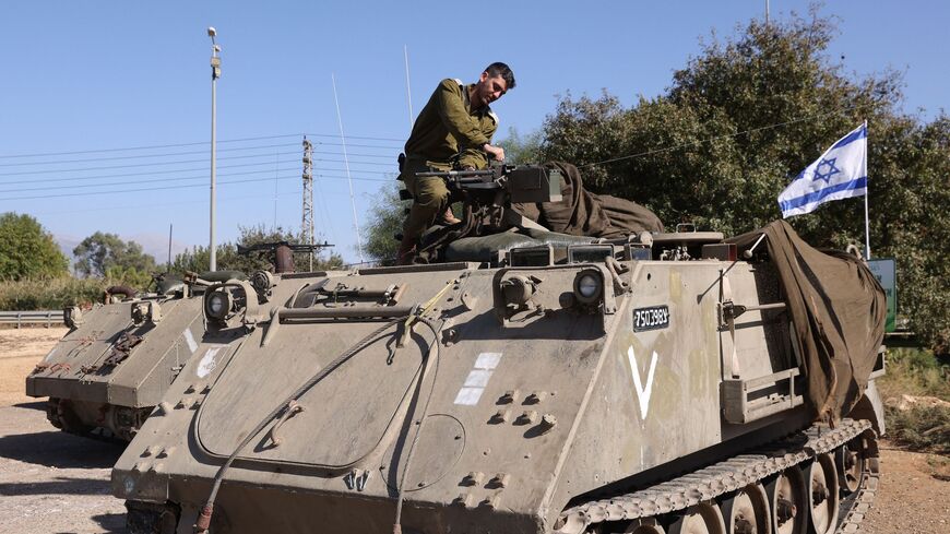 An Israeli soldier works on a tank as troops gather at a position in the upper Galilee region of northern Israel near the border with Lebanon on Nov. 7, 2023.