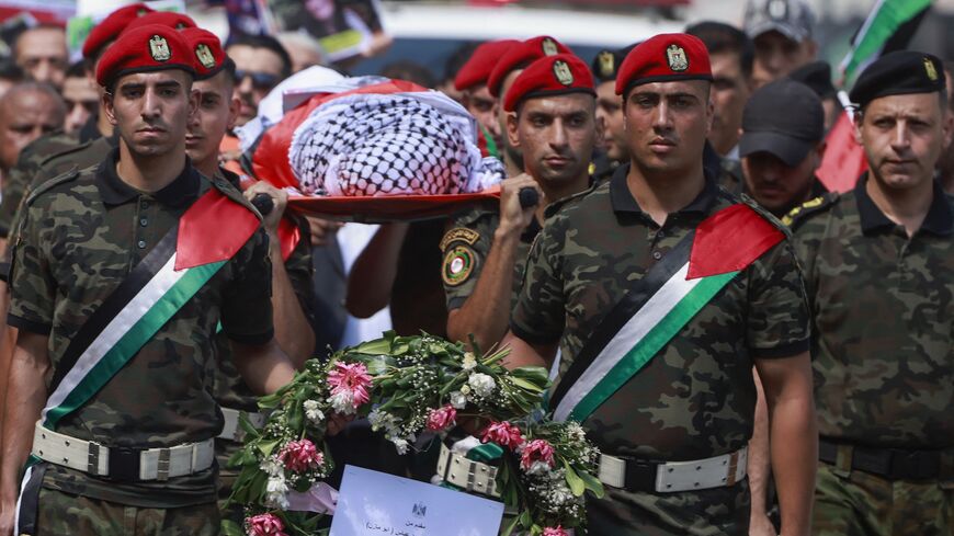 Members of Palestinian security forces carry the body of slain Turkish-American International Solidarity Movement activist Aysenur Ezgi Eygi.