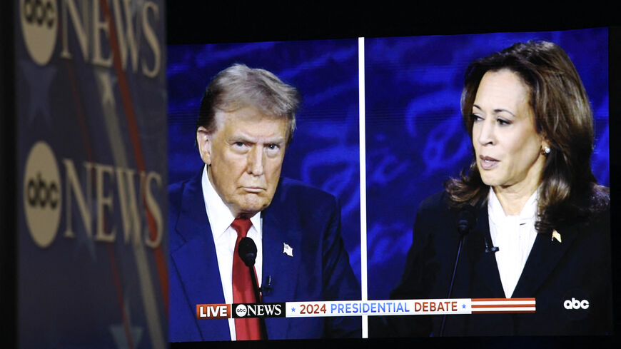 US Vice President and Democratic presidential candidate Kamala Harris and former US President and Republican presidential candidate Donald Trump are seen on a screen in the spin room as they participate in a presidential debate at the National Constitution Center in Philadelphia, Pennsylvania, on Sept. 10, 2024. 