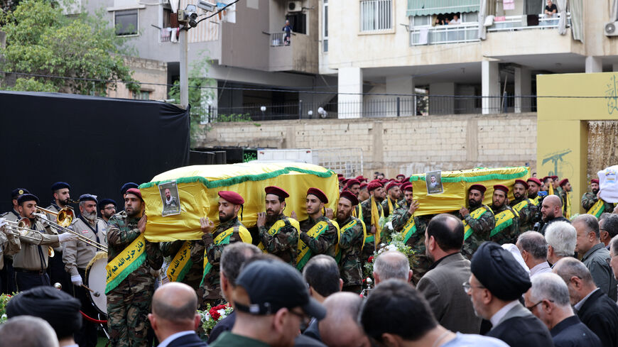 Hezbollah fighters carry the coffins of people killed after hundreds of paging devices exploded in a deadly wave across Lebanon the previous day, during their funeral procession in Beirut's southern suburbs on September 18, 2024. Hundreds of pagers used by Hezbollah members exploded across Lebanon on September 17, killing at least nine people and wounding around 2,800 in blasts the Iran-backed militant group blamed on Israel. (Photo by ANWAR AMRO / AFP) (Photo by ANWAR AMRO/AFP via Getty Images)