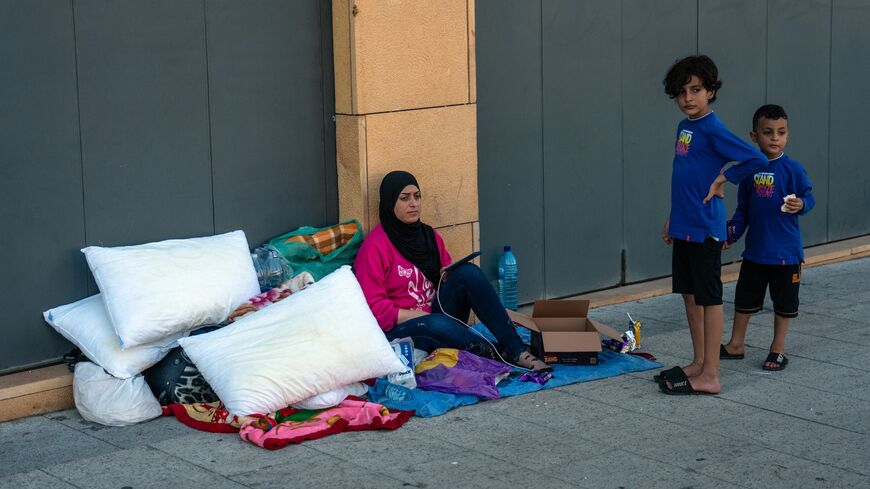 A woman sits with her belongings in Martyrs' Square as she seeks shelter after being displaced by Israeli airstrikes, on Sept. 29, 2024, in Beirut, Lebanon.