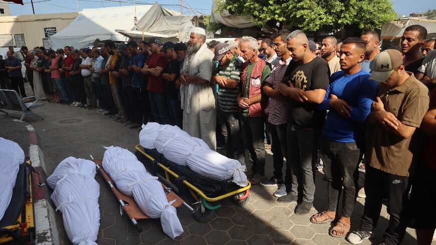 Palestinians mourn over the bodies of victims of Israeli bombardment in Deir el-Balah in central Gaza