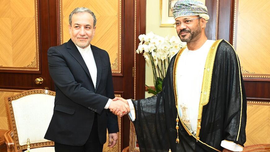 A handout picture provided by the Oman News Agency showing Oman's Foreign Minister Sayyid Badr al-Busaidi (right) receiving Iranian Foreign Minister Abbas Araghchi in Muscat