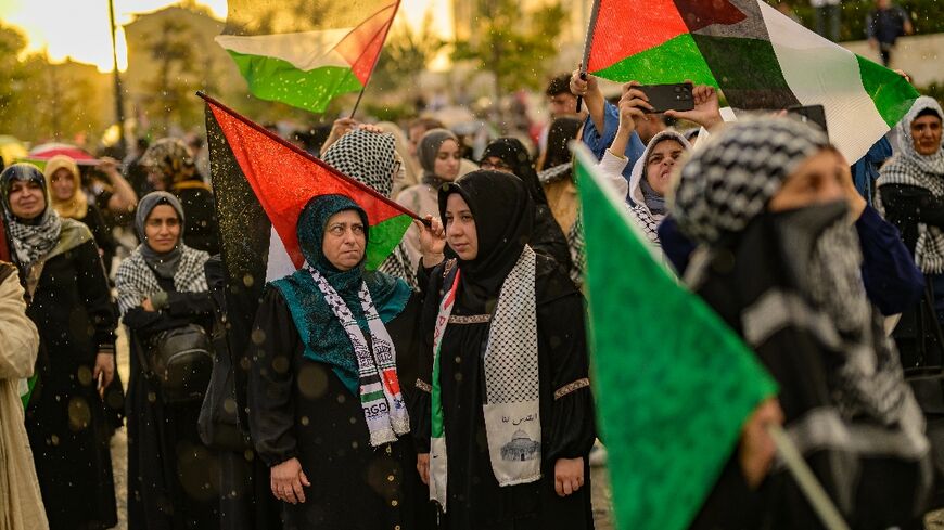 Protesters wave Palestian flags during a rally at the Uskudar Square in Istanbul, Turkey