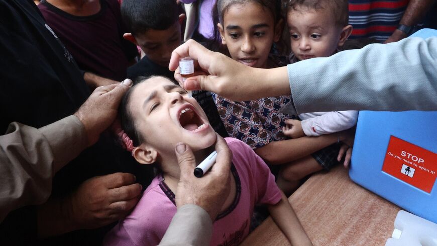 Palestinian children receive drops as part of a polio vaccination campaign in Deir al-Balah in the central Gaza Strip