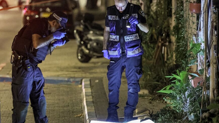 Police forensics experts examine the scene of the deadly knife and gun attack in the Jaffa district of Israel's commercial hub Tel Aviv