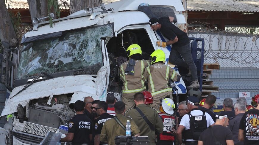 Israeli police and emergency responders recover the body of the truck driver at the site of a ramming in Ramat HaSharon, north of Tel Aviv