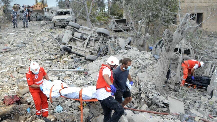 Lebanese Red Cross paramedics transport a body unearthed from the rubble at the site of an Israeli air strike that targeted Aito village in a Christian-majority area far from Hezbollah strongholds