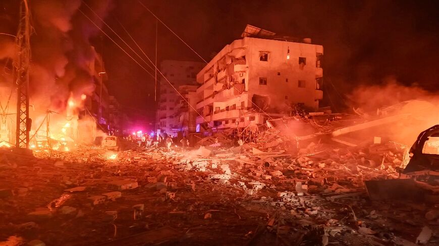 First responders work amid fire and destruction after an Israeli air strike in the southern Lebanese village of Abbasiyeh near Tyre