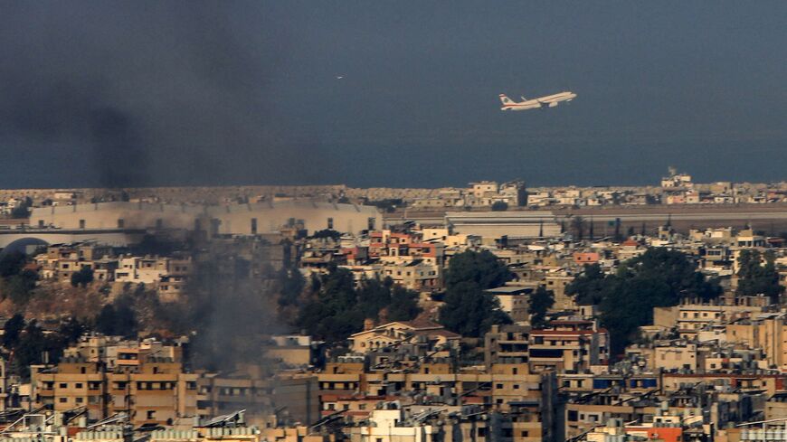 A Middle East Airlines commercial aircraft taking off from Beirut's international airport flies amid smoke billowing above the Lebanese capital's southern suburbs, in the aftermath of overnight Israeli airstrikes, on Sept. 28,2024.