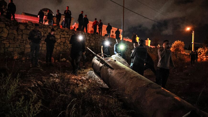 Palestinian youths inspect a fallen projectile after Iran launched a barrage of missiles at Israel.