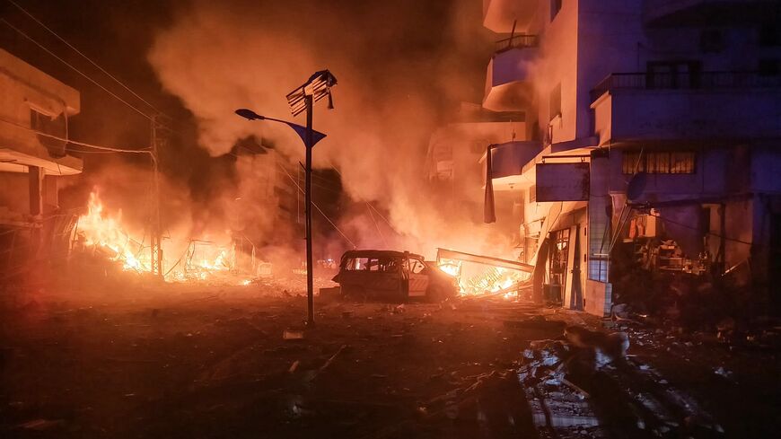 A damaged ambulance lies amid the fire following an Israeli airstrike that targeted the industrial zone in the southern Lebanese village of Abbasiyah on Oct. 30, 2024.