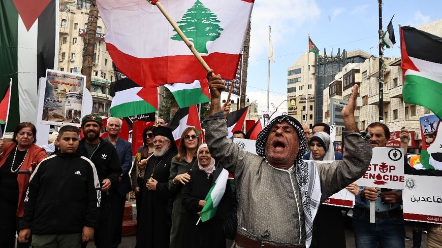 Protesters carry Lebanese flags during a rally to mark the anniversary of Palestinian militant group Hamas's October 7, 2023 attack on Israel, in Ramallah in the occupied West Bank