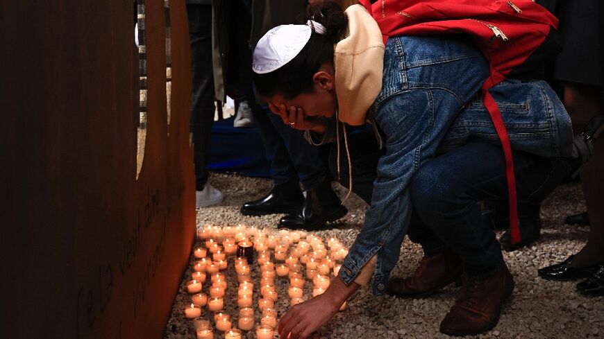 A mourner in Nice, France, lays down a candle at a ceremony in tribute of the victims of October 7 attack