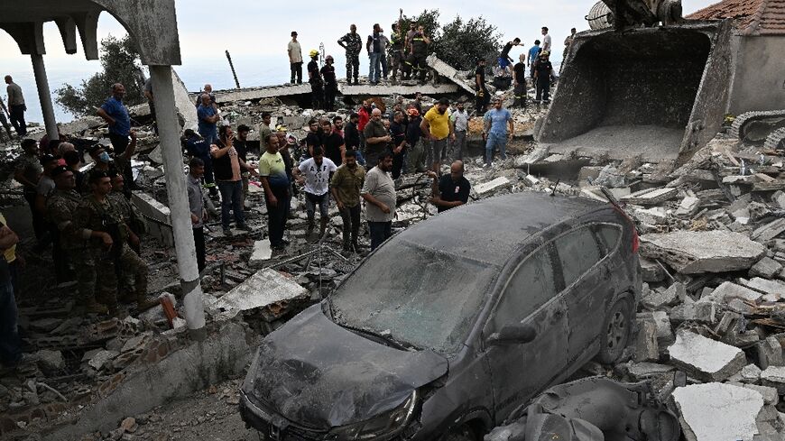 People inspect the damage at the site of an Israeli air strike on Maaysra