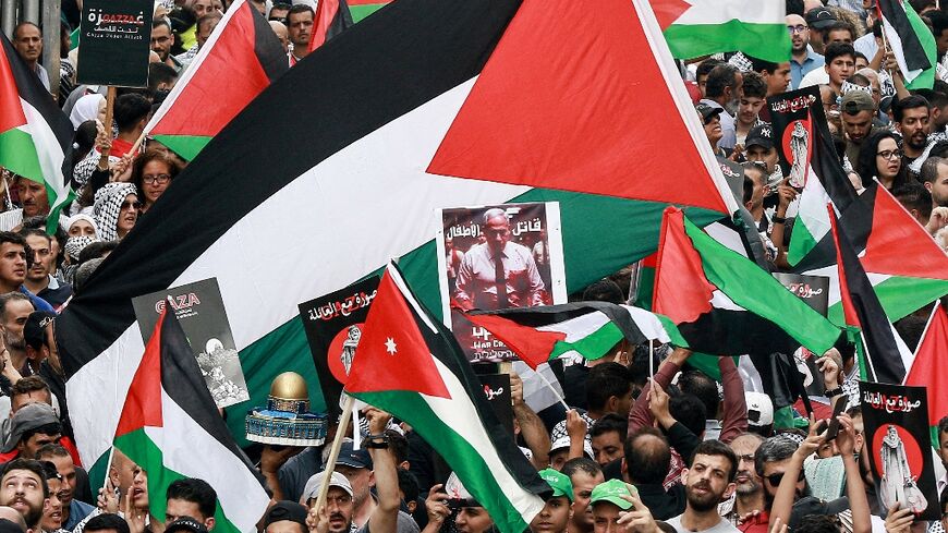 Palestinian flags are waved at a rally in solidarity with Gazans held in Amman, Jordan