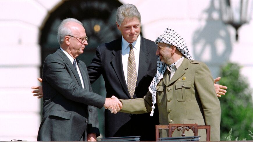 Yitzahk Rabin, left, and Yasser Arafat agree to the Oslo accords as Bill Clinton watches on at the White House on September 13, 1993