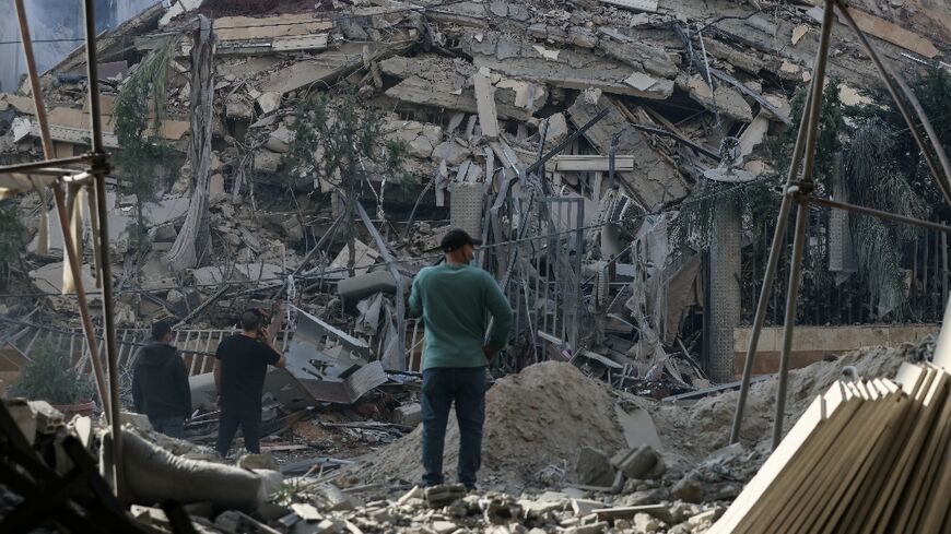 Residents stand in front of a levelled building following an Israeli airstrike that targeted the neighbourhood of Chiyah in Beirut's southern suburbs