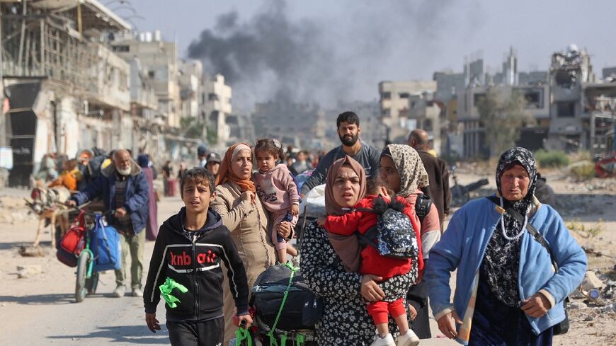 Palestinians displaced from shelters in Beit Hanoun cross the main Salaheddine road into Jabalia in the northern Gaza Strip following Israeli army evacuation orders