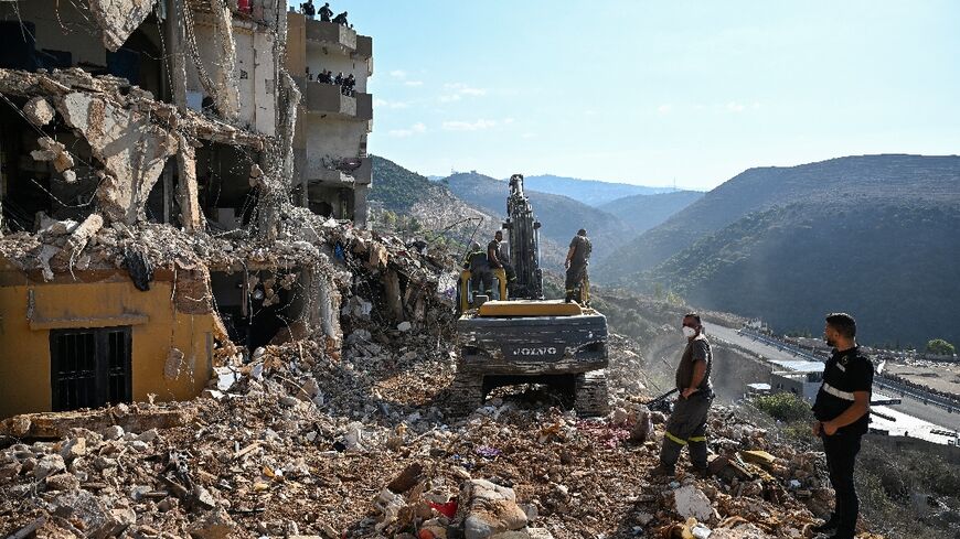 Lebanese emergency services clear the rubble of an apartment block hit by an Israeli strike on the town of Barja, south of Beirut