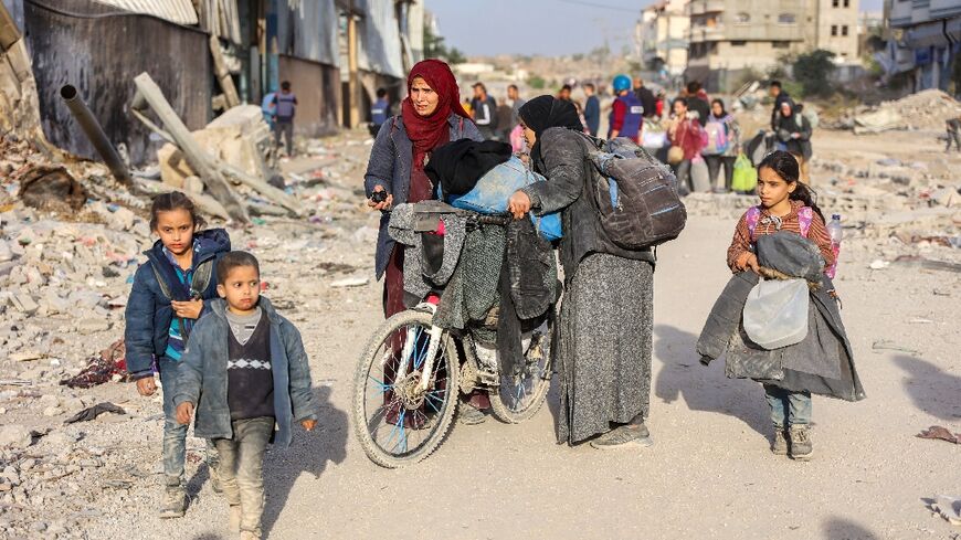 Displaced Palestinians fleeing Beit Lahia in northern Gaza walk on the main Salah al-Din Road