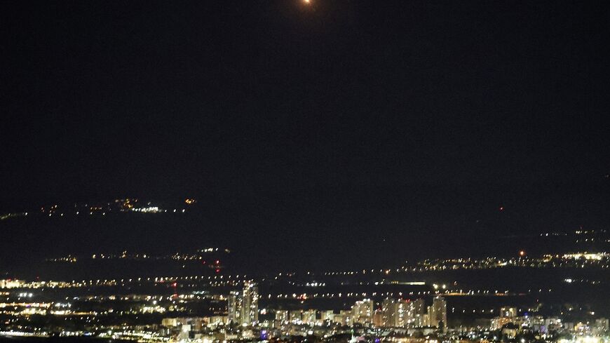 An explosion (top C) as Israel's Iron Dome air defence system intercepts rockets fired from Lebanon over Haifa