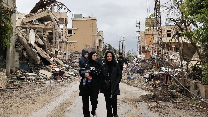 Residents walk amid the destruction in the southern Lebanese village of Zibqin after a ceasefire between Hezbollah and Israel allowed them to return home