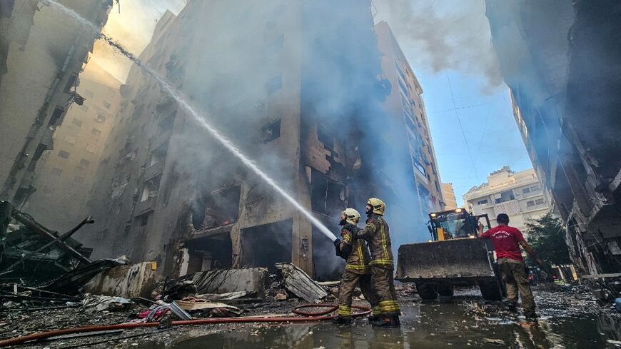 Firefighters battle flames at a buildings hit by an Israeli air strike that targeted the neighbourhood of Haret Hreik in Beirut's southern suburbs