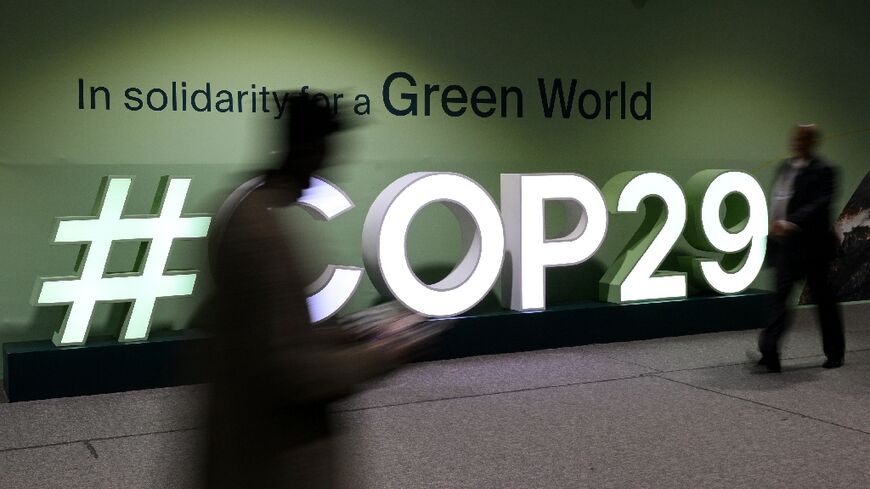 Attendees walk past the COP29 logo during the United Nations climate change talks in Baku, Azerbaijan