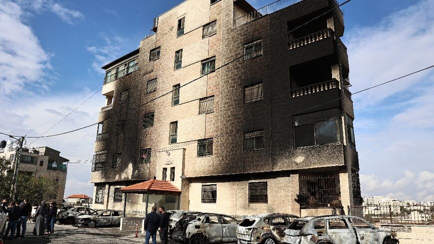 Aftermath of the settler attack: burned out cars and a building's scorched facade