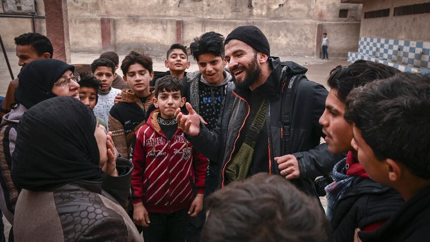 Syrian AFP photographer Sameer al-Doumy meets his neighbours after returning to his old school in Douma near Damascus