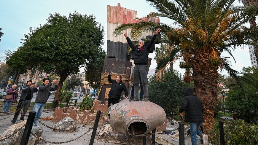 Syrians atop a toppled statue of Hafez al-Assad in Damascus, a highly symbolic moment after five decades of his clan's rule