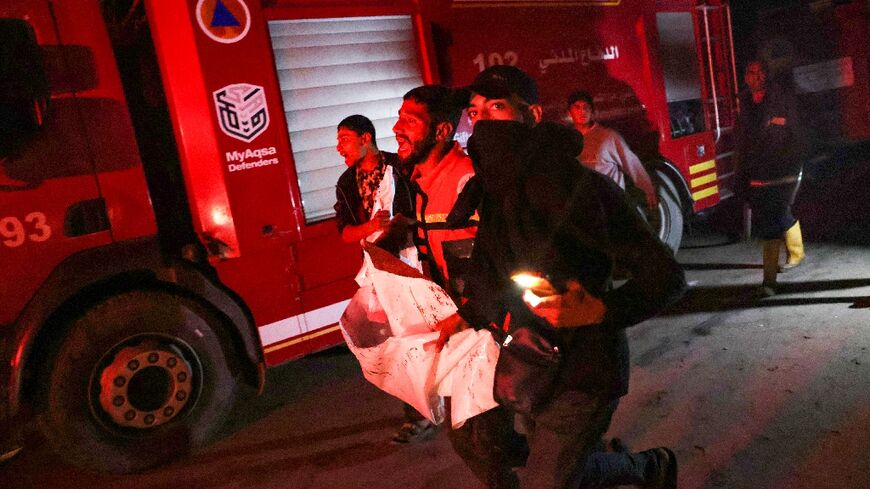 People carry away a victim after an Israeli strike hit a makeshift camp for displaced Palestinians in southern Gaza