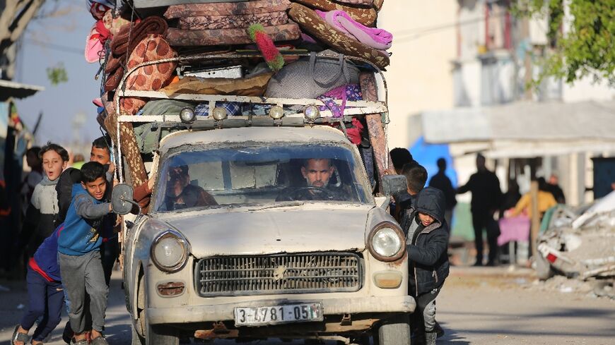 Palestinian children help push a heavily laden vehicle in Gaza's Bureij refugee camp as residents flee in response to the latest evacuation warning from the Israeli military.