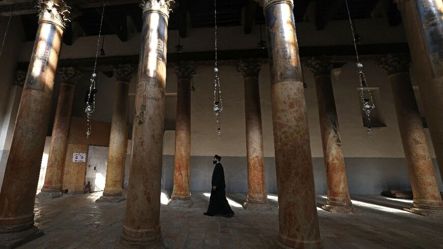 A priest walks in the virtually empty Church of the Nativity in the biblical city of Bethlehem -- thousands would normally visit the church ahead of Christmas