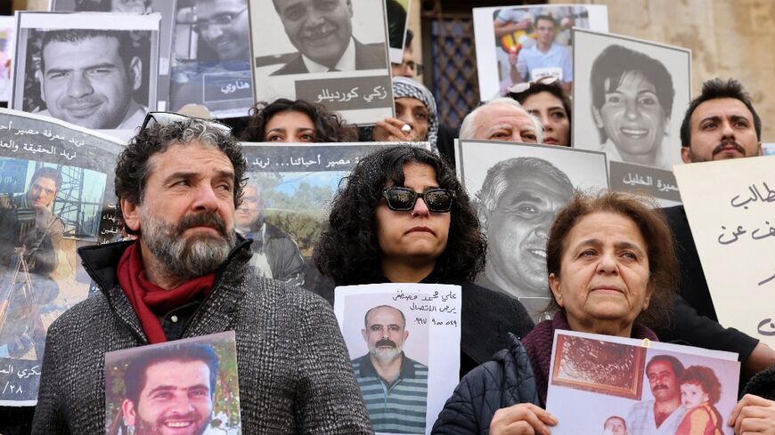 People hold portraits of missing relatives during the protest