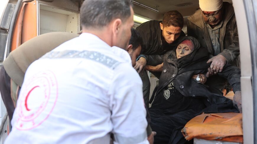 Paramedics put a wounded Palestinian woman into an ambulance in Gaza City