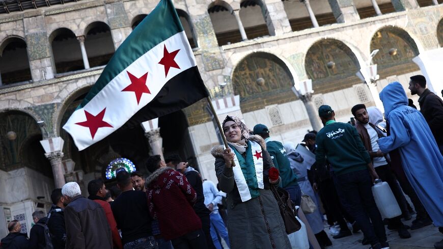 Many people held Syria's independence-era flag as they celebrated Friday prayers at the Umayyad Mosque