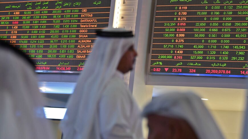 Traders sit below the stock market screens at the Dubai Financial Market, United Arab Emirates, Sept. 16, 2019.