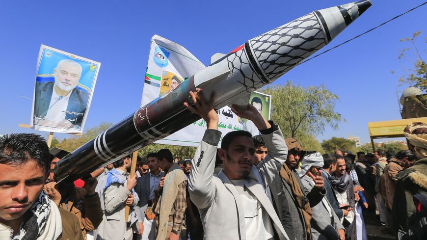 Men carry a mock missile during a rally by university students and faculty denouncing strikes on Yemen and in solidarity with Palestinians.