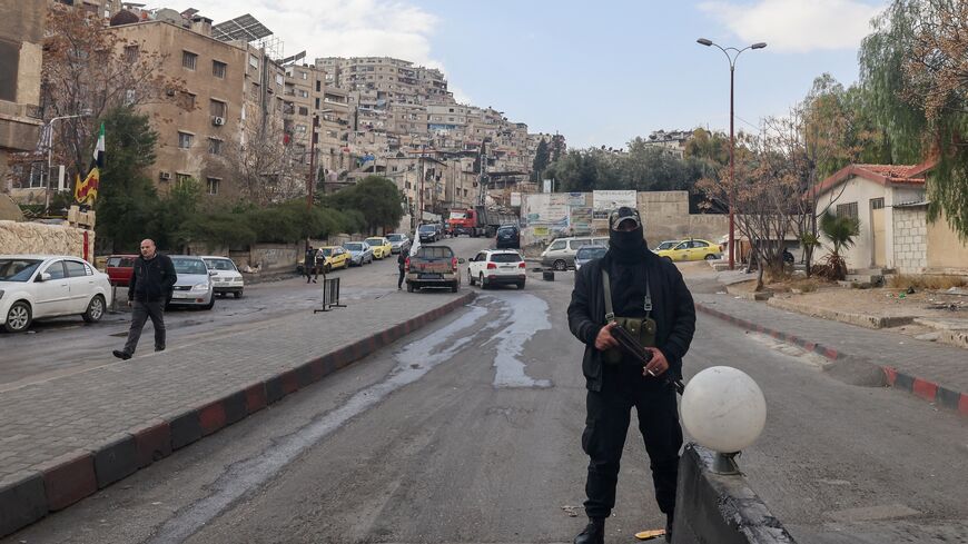 Fighters affiliated with Syria's new administration are deployed after closing a road leading to the Alawite-majority Mazzeh 86 neighbourhood in western Damascus, on Dec. 26, 2024.