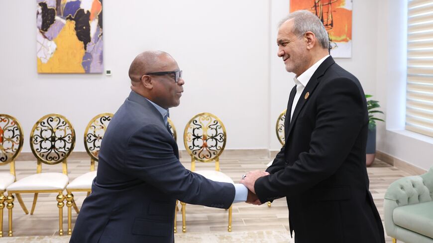 Iranian President Masoud Pezeshkian (R) shakes hands with D-8 Secretary General Isiaka Abdulqadir Imam, Cairo, Dec. 19, 2024.